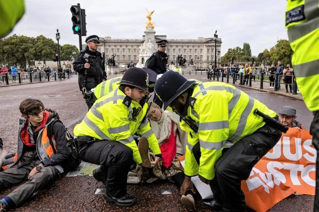 A “Just Stop Oil” protester is removed by police after blocking the Mall outside Buckingham Palace on October 10, 2022 in London, England. Just Stop Oil is a coalition of groups who work together to try and ensure that the government commits to ending all new licenses and consents for the exploration, development and production of fossil fuels in the UK. (Photo by Dan Kitwood/Getty Images)