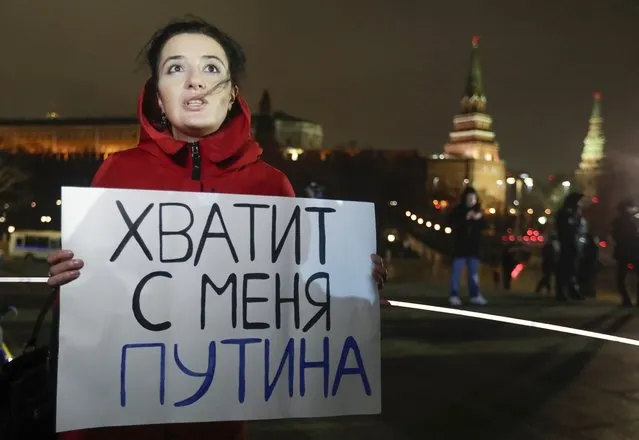 In this file photo taken on Wednesday, March 11, 2020, A protester holds a poster that reads: “Enough Putin for me”, in front of the monument of the Prince Vladimir next to the Kremlin in Moscow. The constitutional reform passed by the Duma on Wednesday would allow Putin to run for presidency two more times after 2024. Before the national vote, it will be reviewed by Russia's Constitutional Court. (Photo by Pavel Golovkin/AP Photo/File)