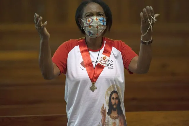 A woman wearing a protective face mask stands in prayer during a Mass at the Metropolitan Cathedral, in Rio de Janeiro, Brazil, Saturday, July 4, 2020. Following an easing of restrictions related to COVID-19, the Catholic church in Rio celebrated its first Mass with 30% of its worshippers, while observing preventive measures to avoid spreading the new coronavirus. (Photo by Leo Correa/AP Photo)