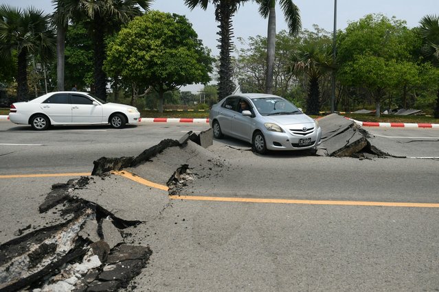 Cars pass a damaged road in Naypyidaw on March 28, 2025, after an earthquake in central Myanmar. A powerful earthquake rocked central Myanmar on March 28, buckling roads in capital Naypyidaw, damaging buildings and forcing people to flee into the streets in neighbouring Thailand. (Photo by Sai Aung Main/AFP Photo)