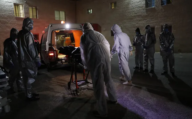 Palestinian health workers bring for burial the dead body of a woman, who has died after contracting the coronavirus disease (C0VID-19), in the West Bank city of Nablus, July 5, 2020. (Photo by APAImages/Rex Features/Shutterstock)