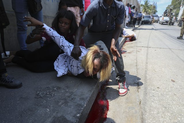 A woman cries after her friend, Valérie Saint-Fort, behind, fell dead from a bullet wound after soldiers fired their guns into the air as a tribute during the funeral of two soldiers in Port-au-Prince, Haiti, Monday, March 17, 2025. (Photo by Odelyn Joseph/AP Photo)