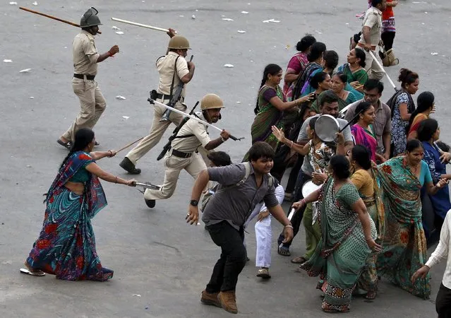 Indian policemen use batons to disperse the members of the Patel community during a protest rally in Ahmedabad, India, September 19, 2015. (Photo by Amit Dave/Reuters)