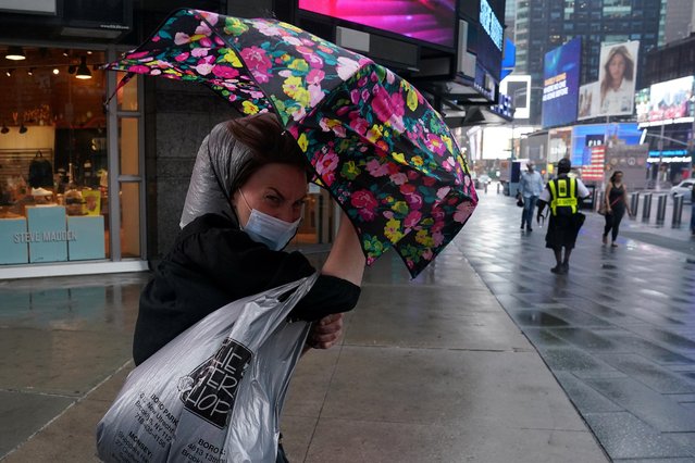 A woman struggles with an umbrella as she walks through Times Square as the city feels the effects of Tropical Storm Isaias in the Manhattan borough of New York City, New York, U.S., August 4, 2020. (Photo by Carlo Allegri/Reuters)