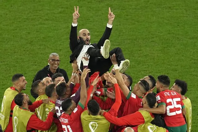Morocco's head coach Walid Regragui is thrown in the air at the end of the World Cup round of 16 soccer match between Morocco and Spain, at the Education City Stadium in Al Rayyan, Qatar, Tuesday, December 6, 2022. (Photo by Abbie Parr/AP Photo)