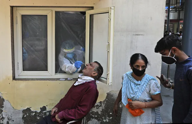 A health worker takes a nasal swab sample to test for COVID-19 in New Delhi, India, Saturday, September 5, 2020. India's coronavirus cases have crossed 4 million, leading the world in new infections and deepening misery in the country's vast hinterlands where surges have crippled the underfunded health care system. Initially, the virus ravaged India's sprawling and densely populated cities. It has since stretched to almost every state, spreading through villages. (Photo by Manish Swarup/AP Photo)