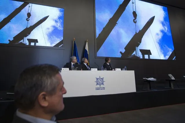 Almaz-Antei director Yan Novikov, center, looks at the screen during a news conference in Moscow, Russia, Tuesday, October 13, 2015. Almaz-Antei air defense consortium, the builder of Buk missiles, presented its vision of the MH-17 air crash based on a new modeling of the disaster they recently conducted. (Photo by Pavel Golovkin/AP Photo)