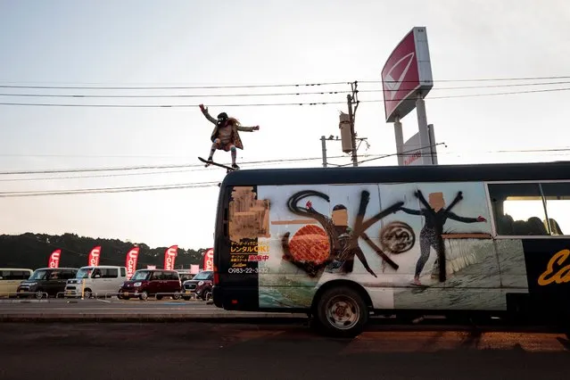 In this picture taken on January 14, 2018, Sky Brown does a roll in as she drops from the top of a bus with her name sprayed on it in Takanabe town, Miyazaki prefecture. Nine-year-old Sky Brown has set her sights on Tokyo 2020, when the hipster sport makes its Olympic bow, along with surfing, karate and sports climbing. (Photo by Behrouz Mehri/AFP Photo)