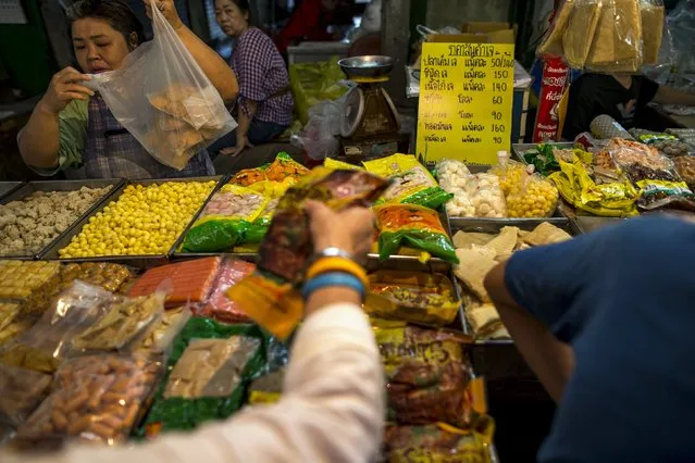 People shop for vegetarian food at a market in Chinatown, Bangkok, Thailand, October 14, 2015. Thailand's annual vegetarian festival kicked off this week, a time of year when the Southeast Asian country's meat-heavy dishes get a vegetarian makeover. (Photo by Athit Perawongmetha/Reuters)
