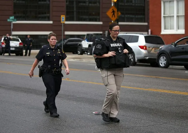 Dallas police officers walk in front of the Dallas Police Department headquarters after an anonymous threat was reported in Dallas, Texas, U.S. July 9, 2016. (Photo by Carlo Allegri/Reuters)
