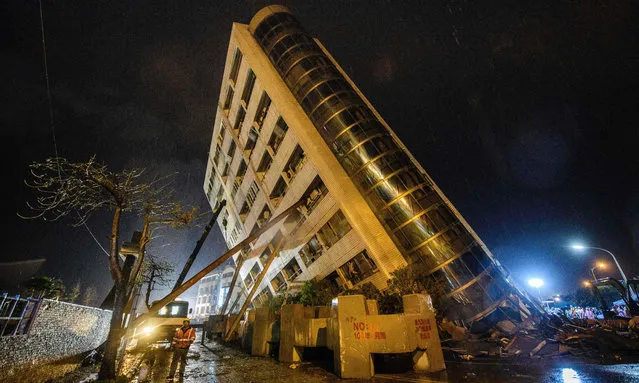 A rescue worker (bottom L) walks past beams used to prop up the Yun Tsui building as it leans to one side after an overnight earthquake in the Taiwanese city of Hualien on February 7, 2018. Rescue workers pulled survivors and bodies from buildings tilting precariously in the Taiwanese city of Hualien on February 7 after an overnight earthquake killed at least six people, injured more than 200 and left dozens missing. Emergency responders were focusing on a 12- storey apartment block and a nearby hotel, both of which were leaning dangerously with their lower floors pancaked after the 6.4- magnitude quake hit the popular tourist city late Tuesday. (Photo by Anthony Wallace/AFP Photo)