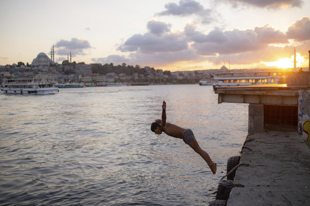 A youth jumps into the Golden Horn in Istanbul, Friday, September 11, 2020. (Photo by Yasin Akgul/AP Photo)