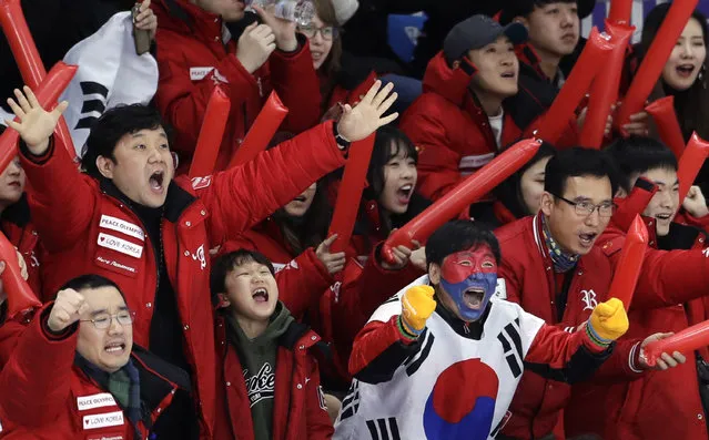 South Koreans celebrate as their fellow countryman Lee Seung-hoon competes during the men's 10,000 meters speedskating race at the Gangneung Oval at the 2018 Winter Olympics in Gangneung, South Korea, Thursday, February 15, 2018. (Photo by Petr David Josek/AP Photo)