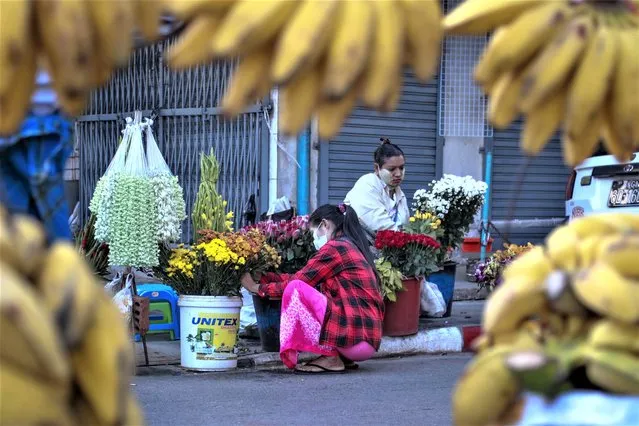 Woman arrange flowers at a street market in Yangon, Myanmar, on February 2, 2021. World Bank economists say Myanmar's economy grew 3% in 2022 and will likely achieve the same pace of growth in 2023, but still lags far behind where it stood before the army seized power in early 2021. (Photo by Thein Zaw/AP Photo)