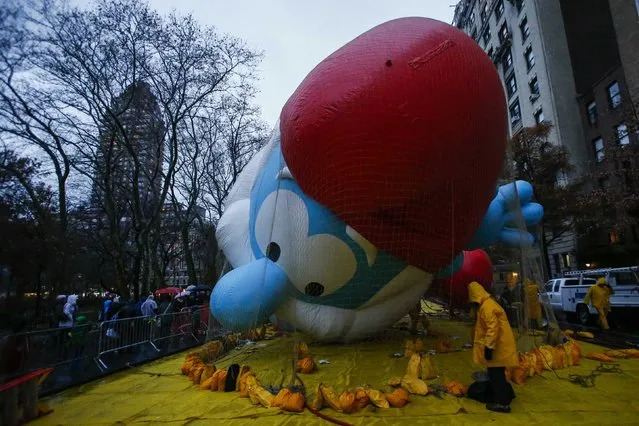 Members of the Macy's Thanksgiving Day Parade balloon inflation team check a balloon during preparations for the 88th annual Macy's Thanksgiving Day Parade in New York, November 26, 2014. (Photo by Eduardo Munoz/Reuters)