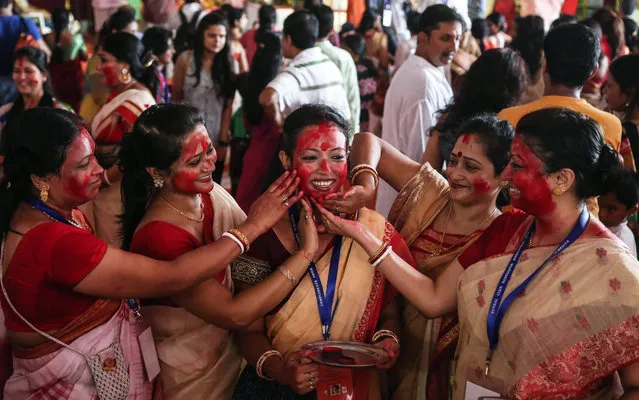 Women devotees of the Bengali community apply Sindoor or vermillion on each other's faces as they take part in the 'Sindoor Puja', a ritual before the immersion of Goddess Durga idols into water bodies on the last day of the Durga Puja Festival in Mumbai, India, 22 October 2015. Sindoor puja marks the end of Durga Puja Festival. (Photo by Divyakant Solanki/EPA)