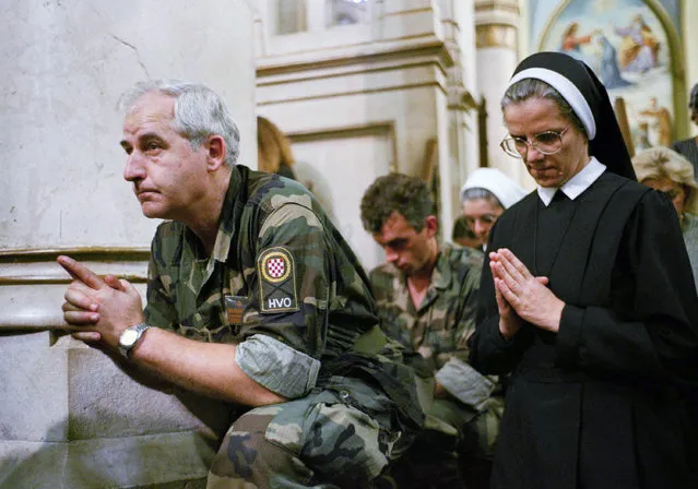 Bosnian Croat soldiers pray close to catholic nun during a mass at Sarajevo's cathedral, Sunday, August 6, 1995, as the Bosnian capital remains quiet. (Photo by Karsten Thielker/AP Photo/File)