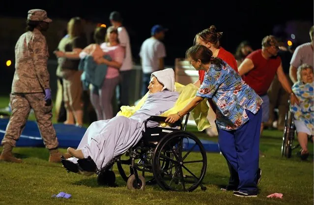 An elderly person is assisted at a staging area at a local school stadium following an explosion at a fertilizer plant Wednesday, April 17, 2013, in West, Texas. (Photo by Rod Aydelotte/AP Photo/ Waco Tribune Herald)