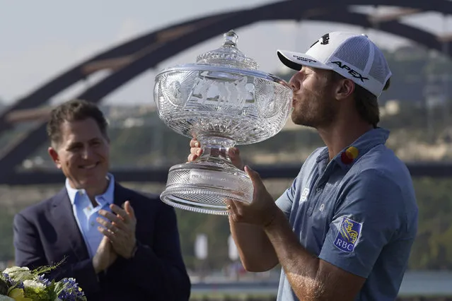 Sam Burns, right, kisses his trophy after defeating Cameron Young in the final match at the Dell Technologies Match Play Championship golf tournament in Austin, Texas, Sunday, March 26, 2023. Michael Dell, left, presented the trophy. (Photo by Eric Gay/AP Photo)