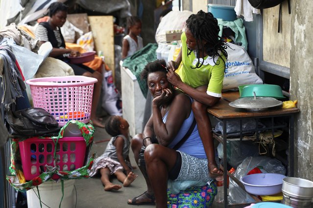 A woman combs the hair of another at a shelter for families displaced by gang violence, in Port-au-Prince, Haiti, Thursday, May 22, 2025. (Photo by Odelyn Joseph/AP Photo)