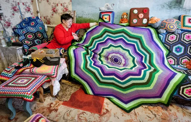 Craftswoman Natalya Savchuk holds a crochet blanket in the village of Martyushevo, Tara District in Omsk Region, Russia on December 7, 2020. (Photo by Sergei Malgavko/TASS)