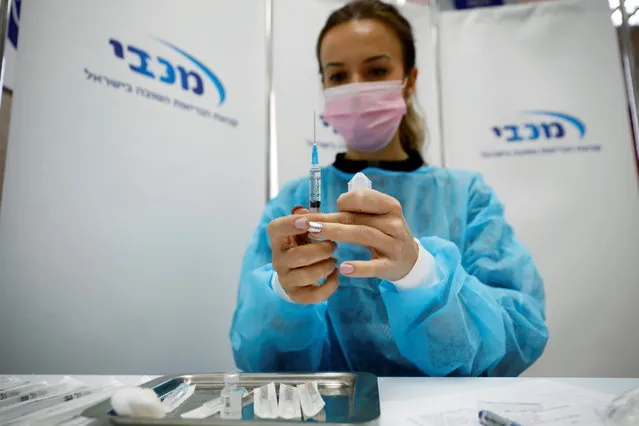 A medical worker prepares to administer a vaccination against the coronavirus disease (COVID-19) as Israel continues its national vaccination drive, during a third national COVID lockdown, at a Maccabi Healthcare Services branch in Ashdod, Israel on December 29, 2020. (Photo by Amir Cohen/Reuters)