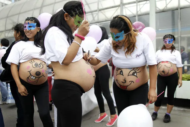 Pregnant women paint their bellies before an event to celebrate “Healthy Maternity Week” in Lima May 30, 2013. About 300 pregnant women participated in celebrations organized by a local hospital seeking to create awareness of healthcare for expectant mothers. (Photo by Enrique Castro-Mendivil/Reuters)