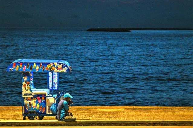 A vendor selling ice cream waits for customers at the Galle Face Beach in Colombo on March 20, 2023. Cash-strapped Sri Lanka is seeking a 10-year moratorium on its foreign debt, President Ranil Wickremesinghe's office said on March 20 on the eve of a desperately needed $2.9 billion IMF bailout. (Photo by Ishara S. Kodikara/AFP Photo)