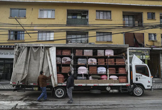 Bergut Funeral Services employees deliver coffins to a funeral store in Santiago, Chile, Friday, June 19, 2020. Coffin production has increased 120%, according to owner Nicolas Bergerie. A basic coffin penned the COVID model was designed to cope with the increase of deaths during the new coronavirus pandemic. (Photo by Esteban Felix/AP Photo)