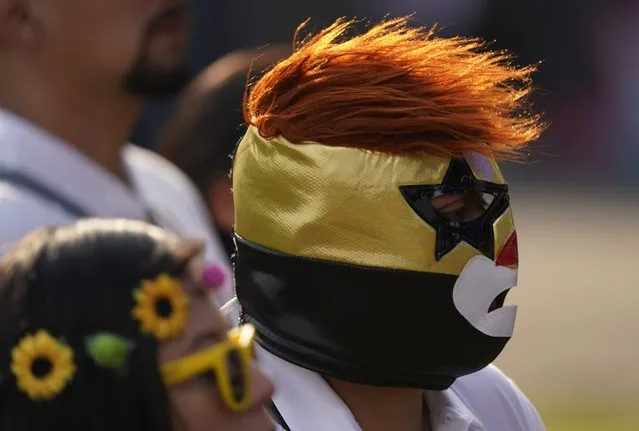 A music fan wears a Lucha Libre wrestlers mask at the Vive Latino music festival in Mexico City, March 20, 2022. The Vive Latino Festival has become Latin America's biggest Latin rock celebration. (Photo by Eduardo Verdugo/AP Photo)