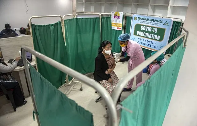 A health worker receives a dose of COVID-19 vaccine at a hospital in Gauhati, India, Thursday, January 21, 2021. India kicked off its massive vaccination drive on Jan. 17, with a goal of inoculating 300 million of its nearly 1.4 billion people. (Photo by Anupam Nath/AP Photo)