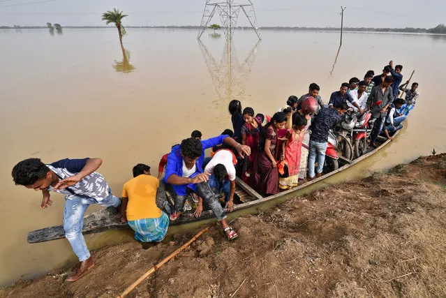 Flood affected villagers arrive at a safer place on a country boat at a village in Hojai district, in the northeastern state of Assam, India, June 16, 2018. (Photo by Anuwar Hazarika/Reuters)