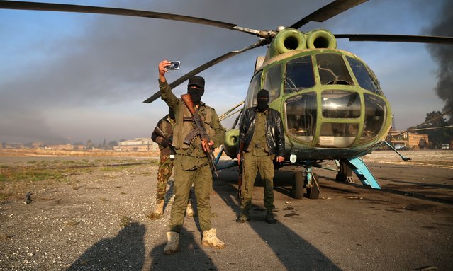 Armed men take selfies at the Nayrab military airport, in Aleppo, Syria, 02 December 2024. Syrian opposition forces, led by the Islamist militant group Hayat Tahrir al-Sham (HTS) launched an offensive on 27 November, taking large parts of Aleppo, Syria's second-largest city. The offensive triggered counterattacks by the Syrian regime forces as well as Russian and Syrian airstrikes on opposition-controlled areas. More than 400 people, including civilians and militants have been killed since 27 November, SOHR stated, while the United Nations Office for the Coordination of Humanitarian Affairs (OCHA) stated that over 20,000 people have been internally displaced within Aleppo and to other governorates. (Photo by Bilal Al Hammoud/EPA/EFE)