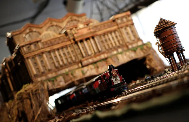 A model train travels under a scaled model of the New York's former Pennsylvania Station built entirely with plant parts during a media preview of the Holiday Train Show at the New York Botanical Garden in the Bronx borough of New York City, U.S., November 14, 2016. (Photo by Mike Segar/Reuters)