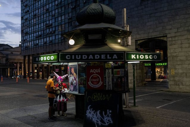 A person in costume makes a purchase at a store ahead of carnival celebrations in downtown Montevideo, Uruguay, Thursday, January 23, 2025. (Photo by Matilde Campodonico/AP Photo)