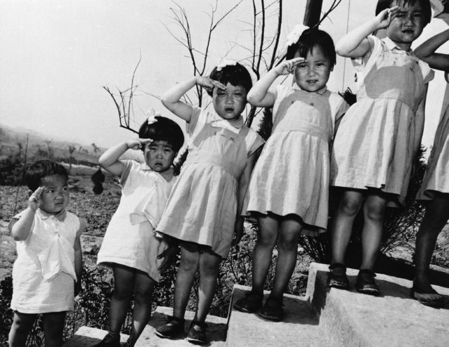 Raising their little hands in salute to Madame Chiang Kai-Shek, are these Chinese children, orphaned by the war in their native land. Madame Chiang visited the children at a War Orphans Home near Chungking in opening ceremonies on May 2, 1944. (Photo by AP Photo)