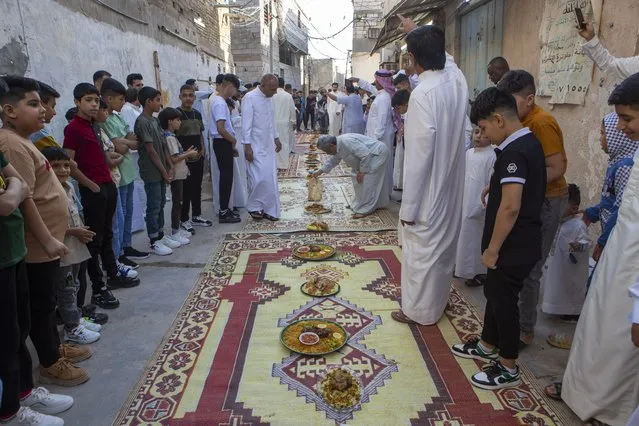 Iraqis eat morning breakfast on the first day of Eid Al-Fitr holiday in Basra, Iraq, Friday, April 21, 2023. Eid Al-Fitr marks the end of the Muslim holy fasting month of Ramadan. (Photo by Nabil al-Jurani/AP Photo)