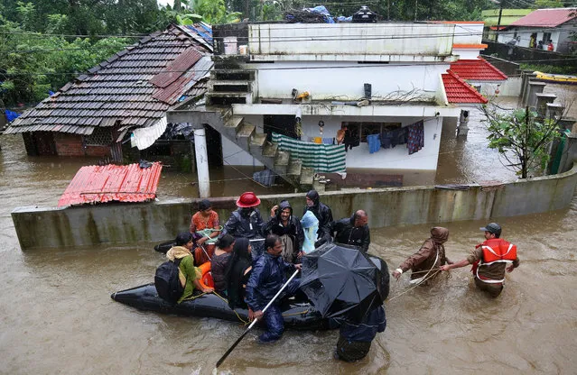 Rescue workers evacuate people from flooded areas after the opening of Idamalayar, Cheruthoni and Mullaperiyar dam shutters following heavy rains, on the outskirts of Kochi, India August 15, 2018. (Photo by Sivaram V/Reuters)