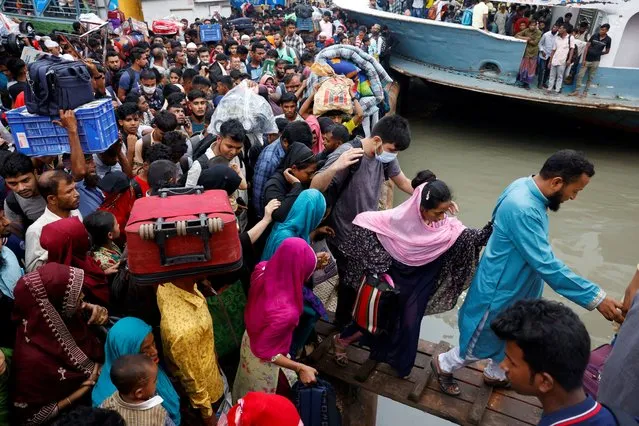 Thousands of people rush to get on board overcrowded ferries at the Sadarghat Ferry Terminal as they leave the capital city to celebrate Eid-al Adha with their families, in Dhaka, Bangladesh on June 27, 2023. (Photo by Mohammad Ponir Hossain/Reuters)