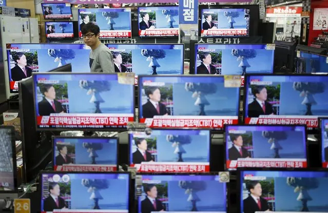 A sales assistant watches TV sets broadcasting a news report on North Korea's nuclear test, in Seoul, January 6, 2016. (Photo by Kim Hong-Ji/Reuters)
