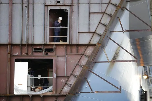 Ship builders work on a section of the Oasis Class 3 cruise ship under construction at the STX Les Chantiers de l'Atlantique shipyard site in Saint-Nazaire, western France, February 17, 2015. (Photo by Stephane Mahe/Reuters)