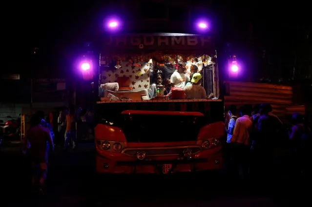 Migrant workers board a bus to return to their villages after Delhi government ordered a six-day lockdown to limit the spread of the coronavirus disease (COVID-19), in Ghaziabad on the outskirts of New Delhi, India, April 19, 2021. (Photo by Adnan Abidi/Reuters)