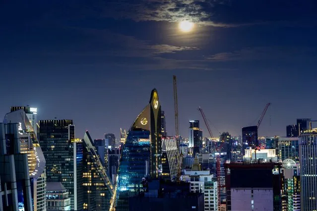 The full Worm Moon is seen over Bangkok's skyline on March 28, 2021. (Photo by Mladen Antonov/AFP Photo)