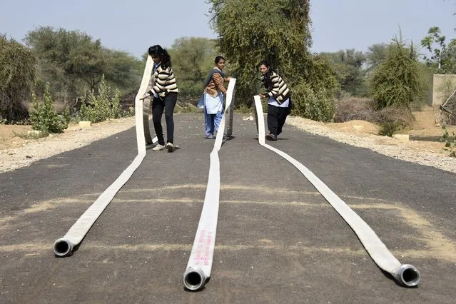 Students adjust hose pipes during a training session at a fire and safety college in Sikar district in the India's desert state of Rajasthan February 9, 2015. Around 30 women were recently recruited from Rajasthan's towns and villages as part of an affirmative action policy to encourage women to join the fire service. (Photo by Reuters/Stringer)