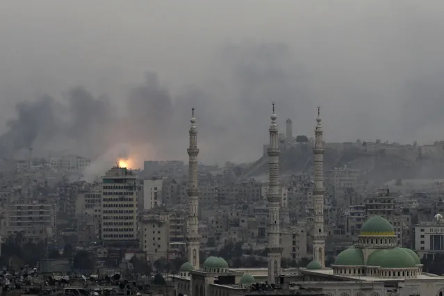 A ball of fire rises following a Syrian government air strike that hit rebel positions in the eastern neighborhoods of Aleppo, Syria, Monday, December 5, 2016. The government seized large swaths of the Aleppo enclave under rebel control since 2012 in the offensive that began last week. The fighting was most intense Monday near the dividing line between east and west Aleppo as government and allied troops push their way from the eastern flank, reaching within less than a kilometer (half a mile) from the citadel that anchors the center of the city. (Photo by Hassan Ammar/AP Photo)