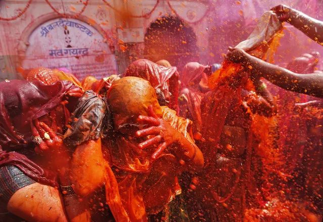 Women cover themselves as men splash coloured water on them during “Huranga” at the Dauji temple, near the northern Indian city of Mathura, March 7, 2015. (Photo by Adnan Abidi/Reuters)