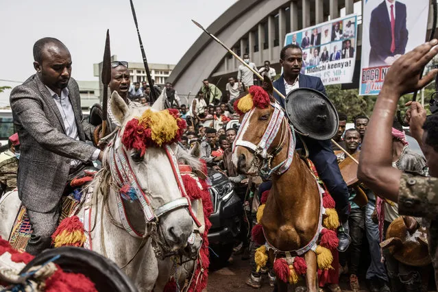 Horsemen are pushed back by soldiers as supporters of the Ethiopian Prime Minister Abiy Ahmed push through the gate to enter the stadium in Jimma on June 16, 2021 where the Prime Minister will conduce an election rally during his electoral campaign ahead of the June 21, 2021 vote. (Photo by Marco Longari/AFP Photo)