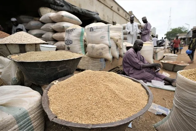 A man sells grain in Dawanau International Market in Kano Nigeria, Friday, July 14, 2023. Nigeria introduced programs before and during Russia's war in Ukraine to make Africa's largest economy self-reliant in wheat production. But climate fallout and insecurity in the northern part of the country where grains are largely grown has hindered the effort. (Photo by Sunday Alamba/AP Photo)
