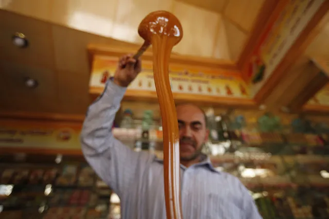A vendor pours honey at his shop in Sanaa, Yemen February 1, 2016. (Photo by Khaled Abdullah/Reuters)