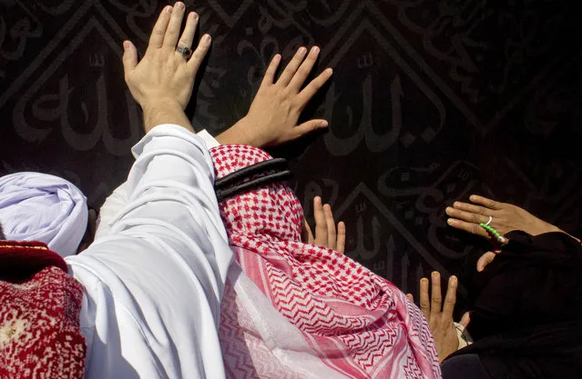 Pilgrims touch the Kaaba, the sacred Muslim shrine, at the Great Mosque in the Muslim holy city of Mecca, Saudi Arabia, Thursday, December 29, 2016, during the minor pilgrimage, known as Umrah. The square stone structure contains a black stone venerated as holy and believers turn towards it when praying. (Photo by Amr Nabil/AP Photo)